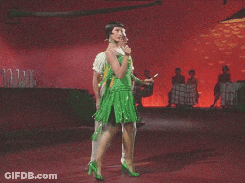 Man In Yellow Vest And Woman In Green Dress Dancing GIF