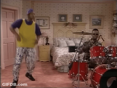 Man In Yellow Vest Dancing Next To Drummer GIF