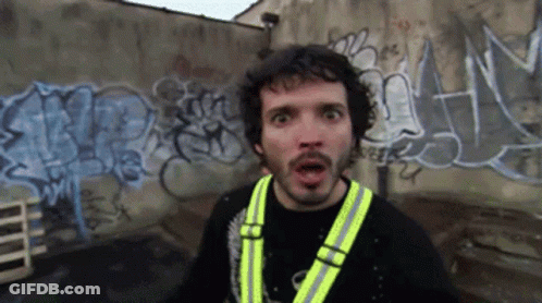 Man In Yellow Vest In Front Of Graffiti Wall GIF
