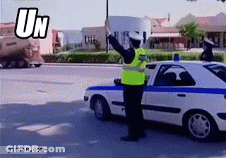 Man In Yellow Vest In Front Of Police Car Saying UN GIF