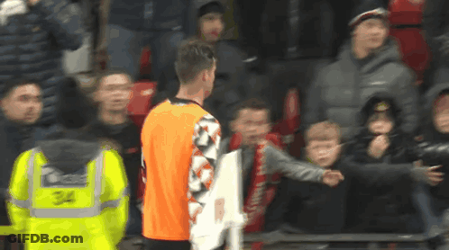 Man In Yellow Vest Number 34 In Front Of Crowd GIF