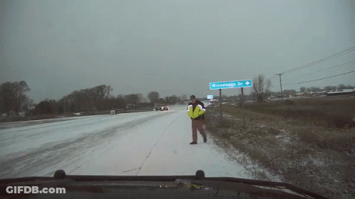 Man In Yellow Vest On Snowy Road Near Winterhage Dr Sign GIF
