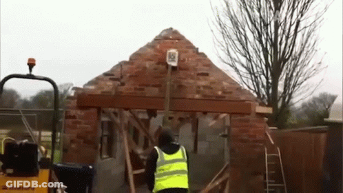Man In Yellow Vest Standing Before Construction GIF