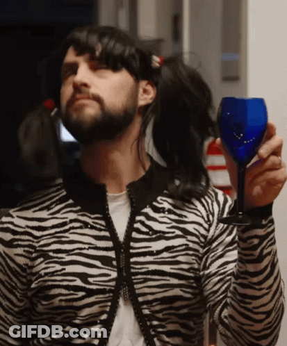 Man In Zebra Print Sweater Holding Blue Glass GIF