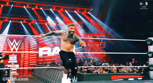 Man Jumping In Wrestling Ring With Crowd Watching GIF