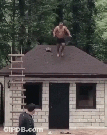 Man Jumping Off Brick Building Roof GIF