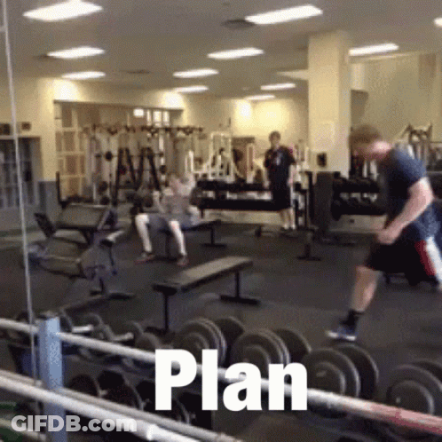 Man Jumping Over Dumbbells With Plan Written On Floor GIF