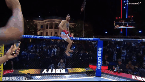 Man Jumping Over Fence With Bud Light Sign GIF