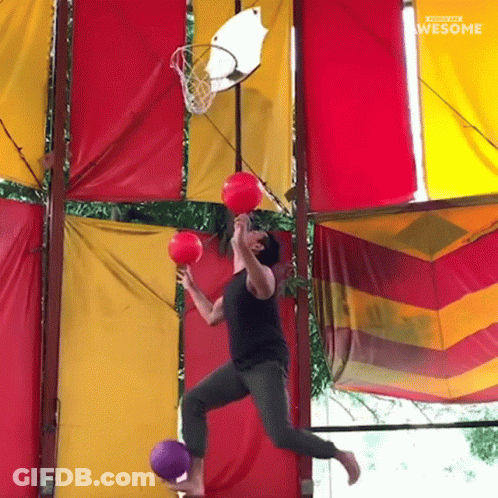 Man Jumping Through Basketball Hoop Holding Two Balls Saying Awesome GIF