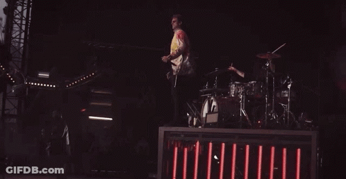 Man Jumping While Playing Drums On Stage GIF