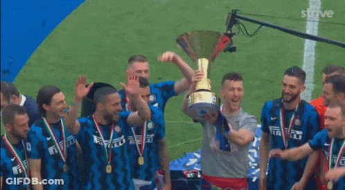Man Kisses Trophy Surrounded By Soccer Players GIF