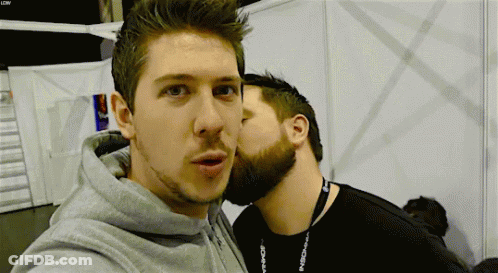 Man Kissing Another Man On Cheek With LDW Lanyard GIF