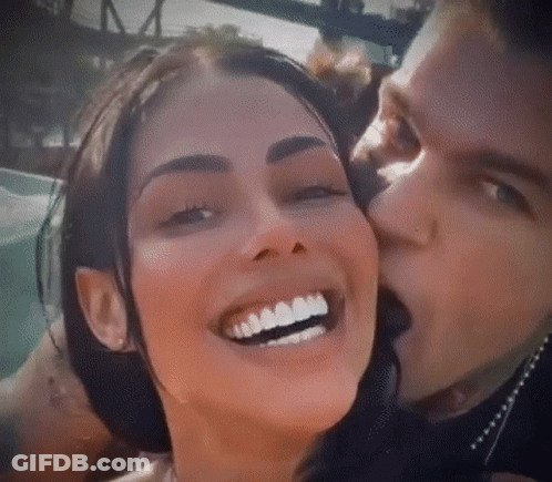 Man Kissing Smiling Woman On Cheek GIF