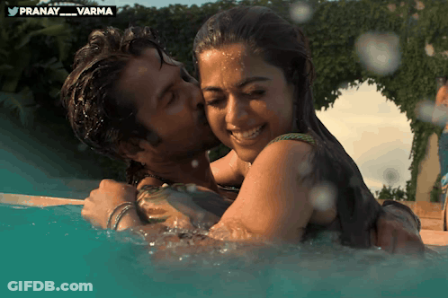 Man Kissing Woman In Pool With Pranay Varma Logo GIF