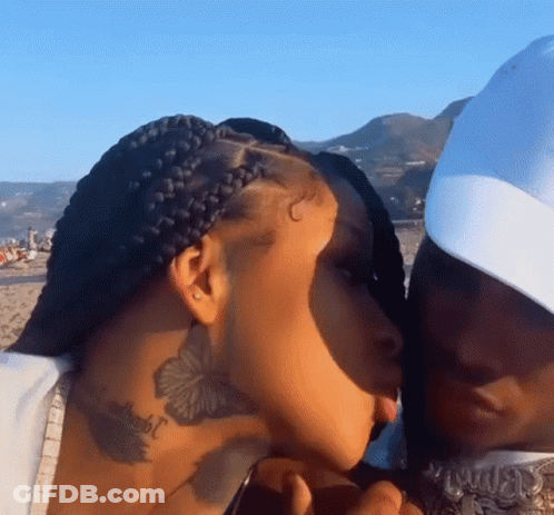 Man Kissing Woman On Cheek On Beach GIF