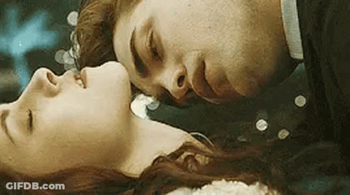 Man Kissing Woman On Forehead Laying Down GIF