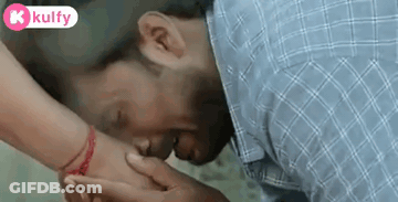 Man Kissing Woman's Hand With Red Bracelet GIF
