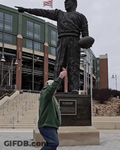 Man Kneeling Before Football Statue GIF