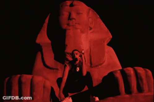 Man Kneeling Before Sphinx In Red Light GIF