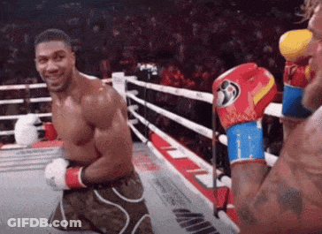 Man Kneeling In Boxing Ring Smiling GIF