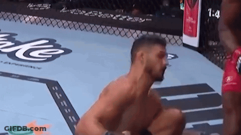 Man Kneeling In Boxing Ring With Another Man Behind GIF