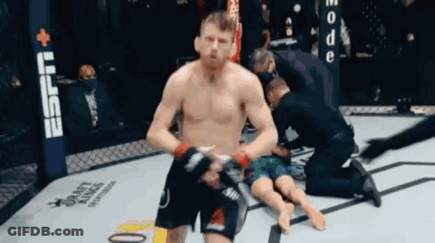 Man Kneeling In Boxing Ring With Referee GIF