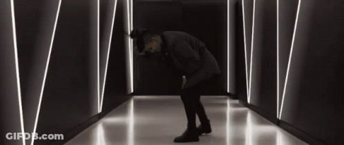 Man Kneeling In Dark Hallway With Lines GIF