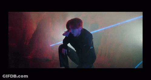 Man Kneeling In Dark Room With Laser GIF