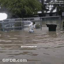 Man Kneeling In Flooded Area GIF