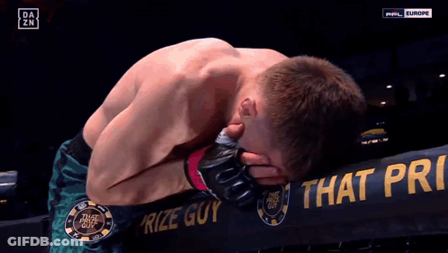 Man Kneeling In Front Of Prize Guy Sign GIF