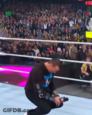 Man Kneeling In Wrestling Ring Holding Camera GIF