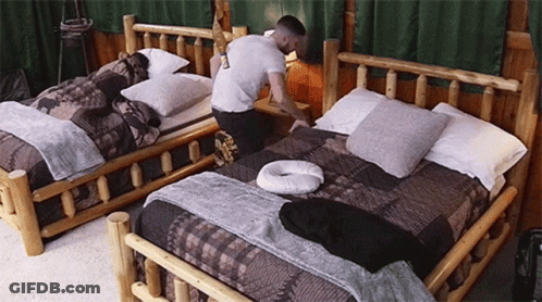 Man Kneeling On Bed In Bedroom GIF