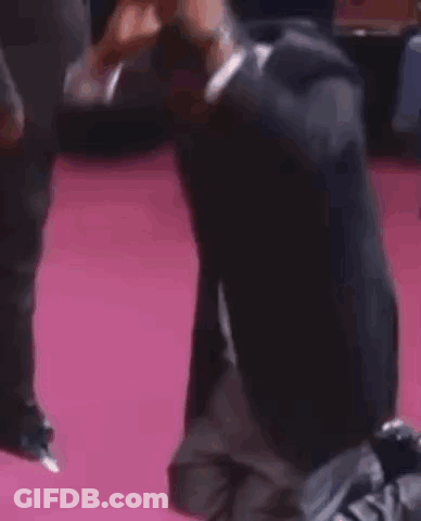 Man Kneeling On Pink Carpet GIF