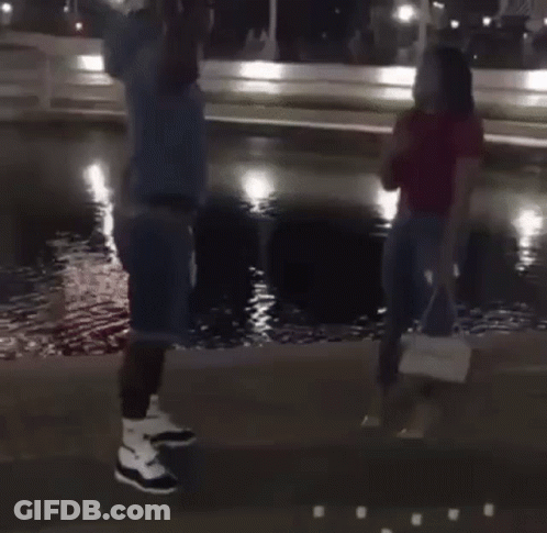 Man Kneeling Proposing To Woman In Front Of Fountain GIF