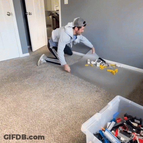 Man Kneeling With Box Of Lego Bricks GIF