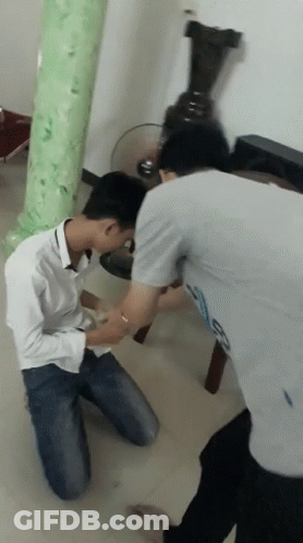 Man Kneeling With Hands On Another Man's Waist GIF