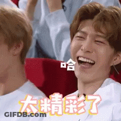 Man Laughing In Theater With Chinese Writing On Screen GIF