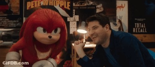 Man Laughing Next To Stuffed Animal With Pete Whipple Poster GIF