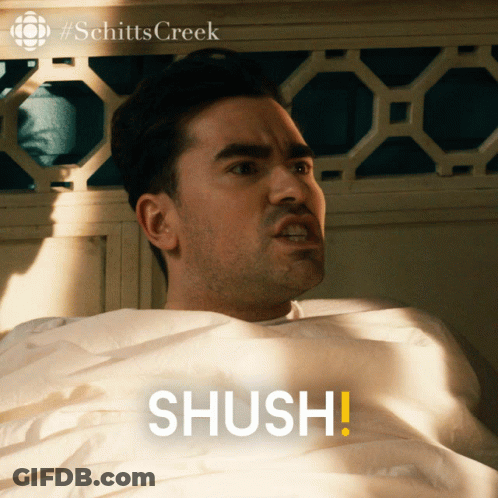 Man Laying In Bed Saying Shush GIF