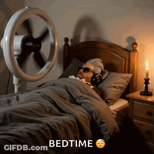 Man Laying In Bed With Fan Saying Bedtime GIF