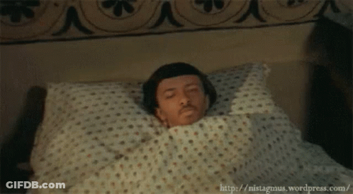 Man Laying In Bed With Polka Dot Blanket GIF