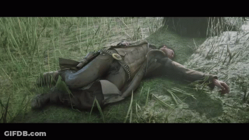 Man Laying In Grass With Gun GIF