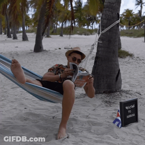 Man Laying In Hammock Reading Book Next To Welcome To Salomon Sign GIF