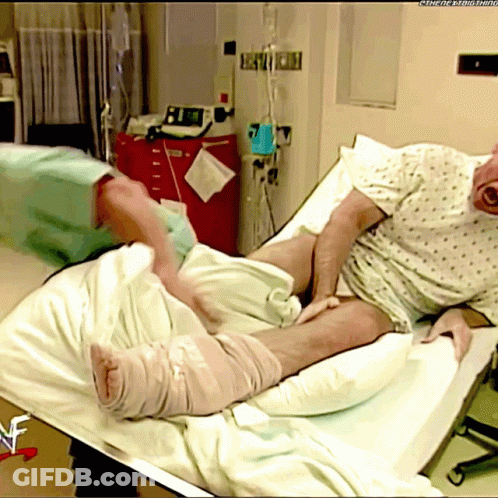 Man Laying In Hospital Bed With WWE Logo GIF