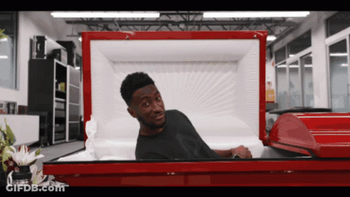 Man Laying In Red Coffin With Head Sticking Out GIF