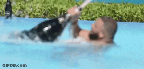 Man Laying In Water Holding Champagne GIF