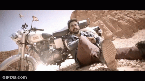 Man Laying Next To White Royal Enfield Motorcycle GIF