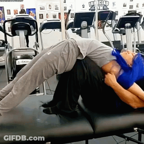 Man Laying On Another Man's Back At Iron Clad Gym GIF