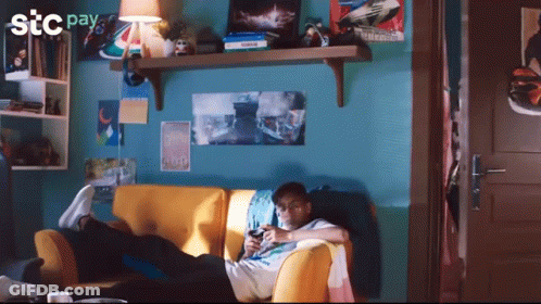 Man Laying On Couch Playing Video Game With STC Pay Logo GIF