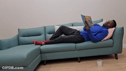 Man Laying On Couch Reading Magazine GIF